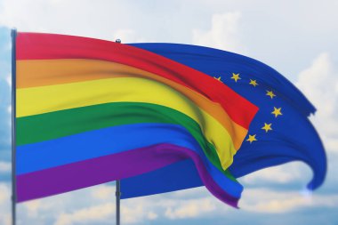 Avrupa Birliği bayrağı sallayan 3D illüstrasyon ve gökkuşağı bayrağı, LGBT gurur bayrağı veya rüzgarda sallanan eşcinsel gurur bayrağı. Sığ bir alan derinliği ve seçici bir odaklanma ile vurulmuş..