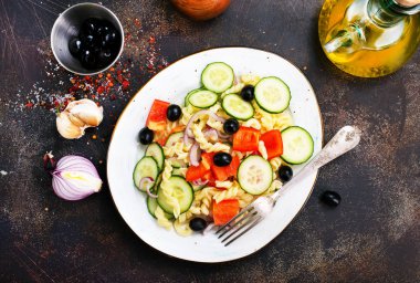 Makarna ve sebzeler plaka üzerinde lezzetli salata 