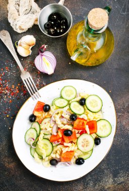 Makarna ve sebzeler plaka üzerinde lezzetli salata 