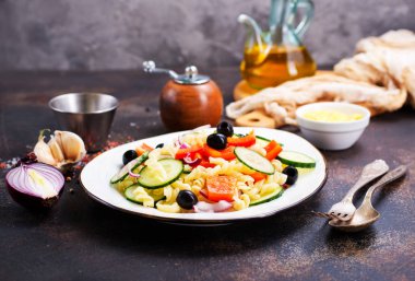 Makarna ve sebzeler plaka üzerinde lezzetli salata 