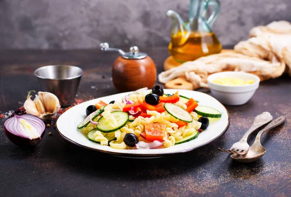 Makarna ve sebzeler plaka üzerinde lezzetli salata 