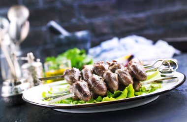 kızarmış tavuk kalpler Kebap beyaz tabakta marul ile 