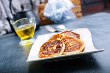 Beyaz tabakta bal ile kızarmış krep 