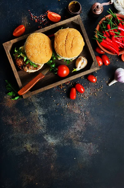 homemade burgers with hot chili peppers in wooden box