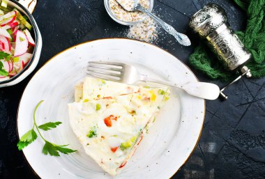 Beyaz tabakta sebze ile lezzetli omlet