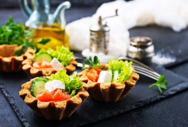 tartlets tuzlu somon ve yeşilliklerle taş levha ile kümesi 