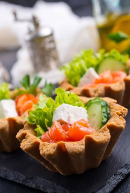 tartlets tuzlu somon ve yeşilliklerle taş levha ile kümesi 