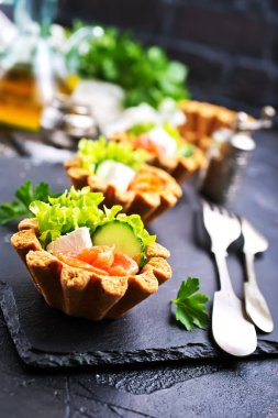 taze somon ve sebzeler üzerinde taş levha ile lezzetli tartlets 