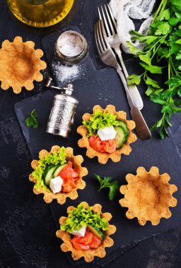 salatalık ve somon salata, tuz ve masada çatal ile Tartlets 