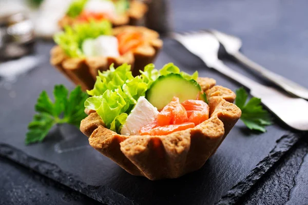 taze somon ve sebzeler üzerinde taş levha ile lezzetli tartlets 
