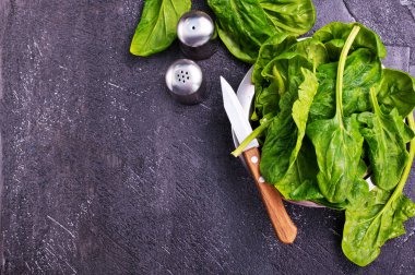 taze ıspanak yaprakları ve bıçak masada