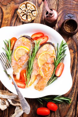 Beyaz tabakta sebze ile pişmiş somon