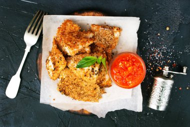 domates soslu kızarmış balık çatal ve masada, üstten görünüm tuz