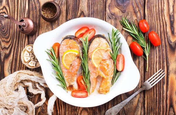 запеченный лосось с овощами на белой тарелке
