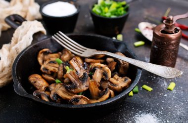 Fried mantar ve tavada yeşil soğan
