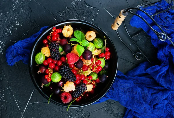 トップ ビューでは テーブル上のボウルに盛り合わせ新鮮で熟した果実 — ストック写真