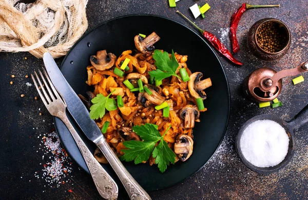 Vegan dish. Fried mushrooms and cabbage in the frying pan. European cuisine.