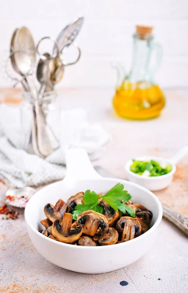 Vegan dish. Fried mushrooms and onion in the frying pan. European cuisine.