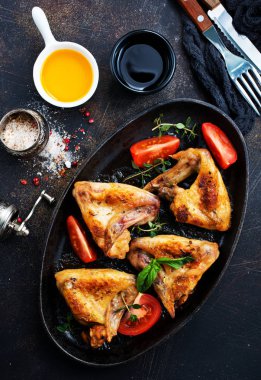 Fırında tavuk kanadı domates dilimleri ile bölümü