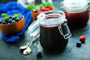 Ev yapımı reçel kavanoz ve arka plan üzerinde taze çilek