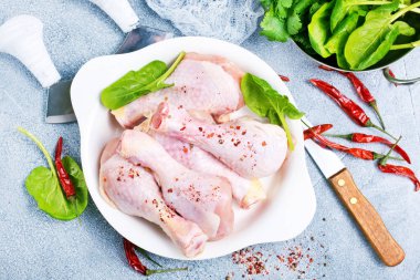 çiğ tavuk budu kase içinde baharatlar ile üstten görünüm