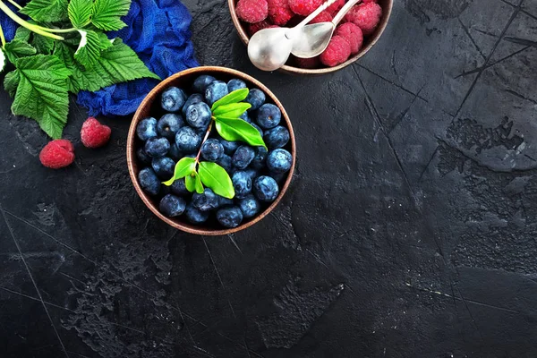 顶部查看新鲜蓝莓和树莓在桌上服务的木碗 — 图库照片