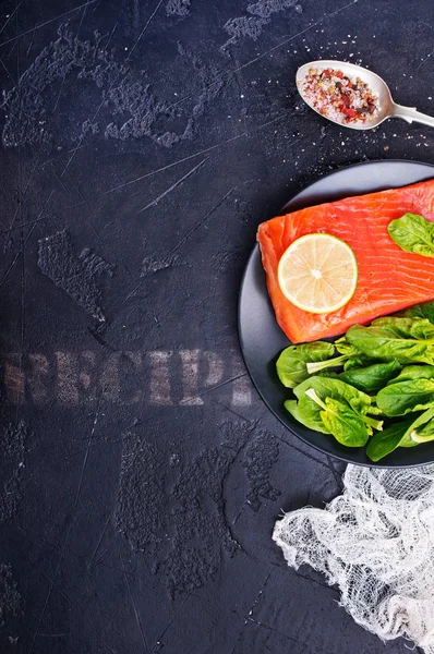 三文鱼排配石灰片和新鲜菠菜在盘子上的顶部视图 — 图库照片