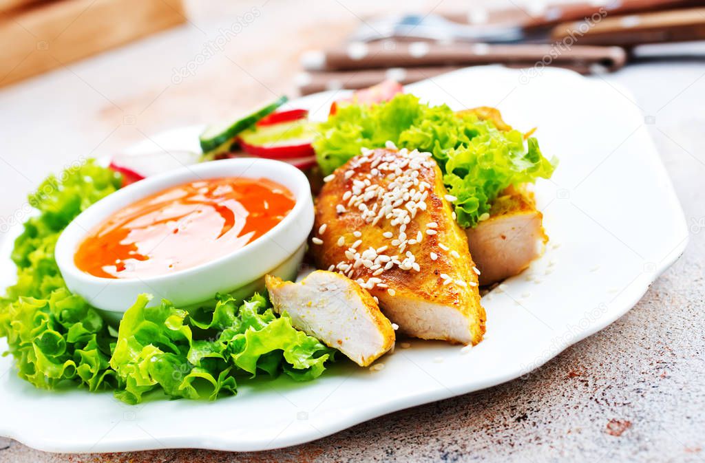 chicken nuggets with salad and sweet chilli sauce served on table