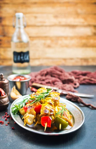 chicken kebab with vegetables on metal plate