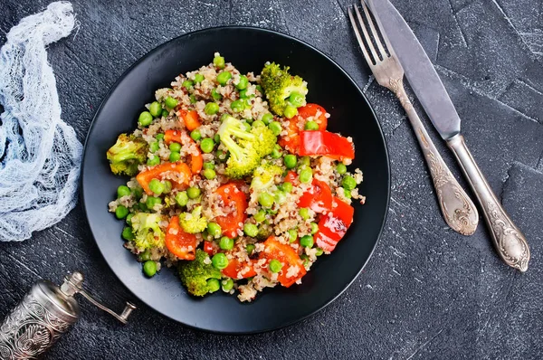 Quinoa salad with tomatoes, avocado, broccoli and green peas on plate