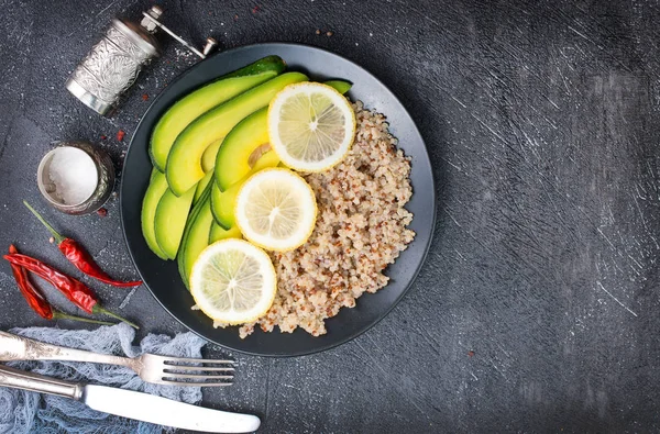 Quinoa ile siyah bir zemin üzerine kireç avokado ve mutfak bıçakları