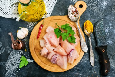 üstten görünüm doğranmış çiğ tavuk fileto tuz ve aroma ile üzerinde siyah arka plan üzerine baharat