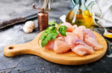 Ahşap tahta üzerinde maydanoz ile doğranmış çiğ tavuk fileto