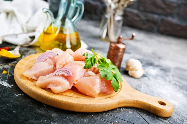 Ahşap tahta üzerinde zeytinyağı ile doğranmış çiğ tavuk fileto