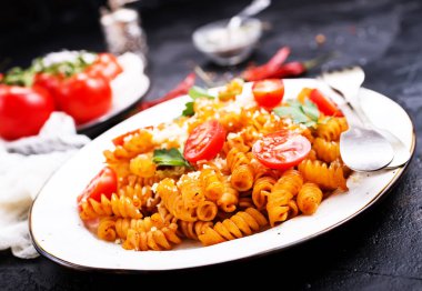 koyu zemin üzerine domates sosu ve rendelenmiş peynir ile pişmiş makarna görünümü kadar kapatın