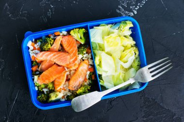 karanlık masada lezzetli ev yapımı sağlıklı yiyecek öğle yemeği kutusu ve çatal üstten görünüm