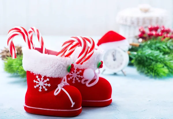 关闭圣诞节装饰靴与糖果藤条在蓝色桌面上的特写视图 — 图库照片