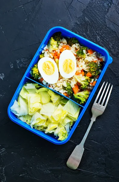 在黑暗的表面上的饭盒和叉子上看到新鲜健康的食物 — 图库照片