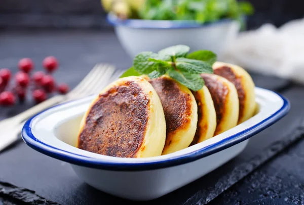 cottage cheese pancakes syrniki on plate, cheese pancakes and mint leaves