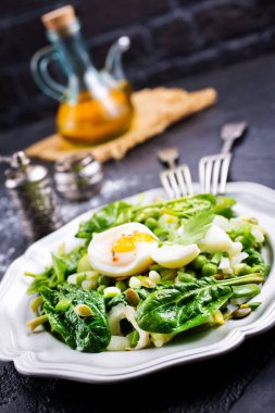 haşlanmış yumurta ve plaka üzerinde taze ıspanak salatası