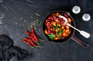 maydanoz gri masa üzerinde tavada kızarmış fasulye