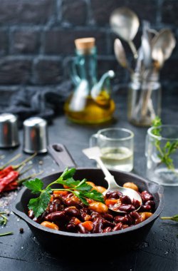 maydanoz gri masa üzerinde tavada kızarmış fasulye