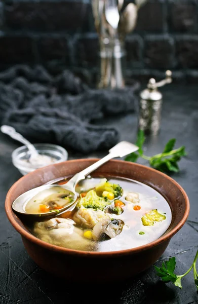 homemade soup with mushrooms and vegetables in bowl on black surface