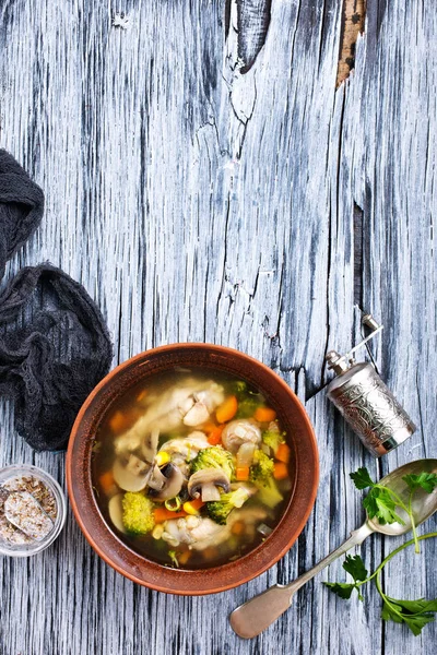 homemade soup with mushrooms and vegetables in bowl on wooden table