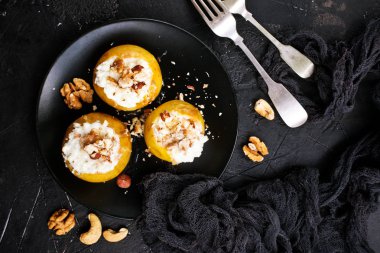 siyah plaka üzerinde fındık ve bal ile pişmiş elma üstten görünüm