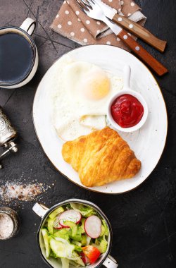 bir tablo, kızarmış yumurta ve kruvasan kahvaltı