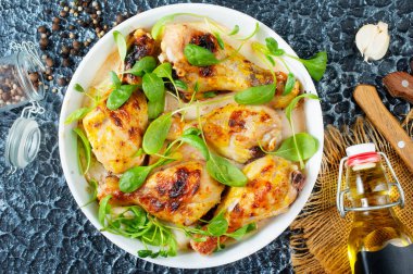 Tavuk budu tabakta, kızarmış tavuk budu ve ıspanak.