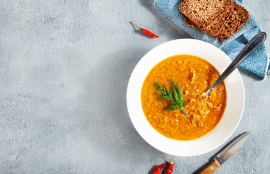 Beyaz tabakta kırmızı mercimek çorbası, üst manzara, geleneksel Türk yemeği veya Arap mercimeği ve sebze çorbası..