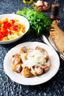 Kızarmış tavuk filetosu ve tabakta beyaz soğan.