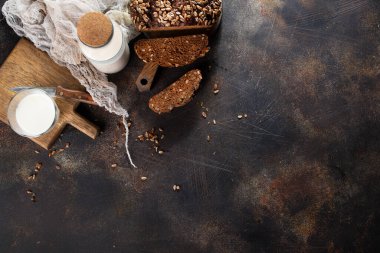 Ev yapımı çavdar ekmeği, ayçekirdeği ve eski masada bir şişe süt.